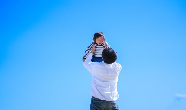 子どもを抱き上げる父親