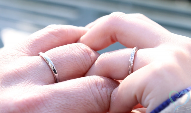 結婚指輪をした男女が手を触れ合う