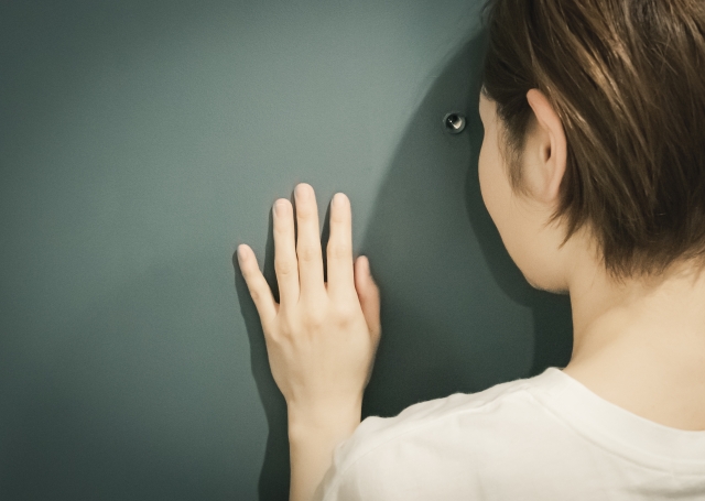 鍵穴をのぞく女性