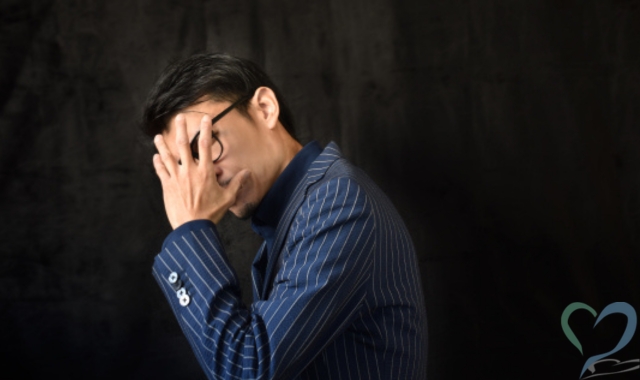 顔を覆う男
