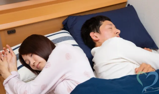お互いに背を向けて眠る夫婦
