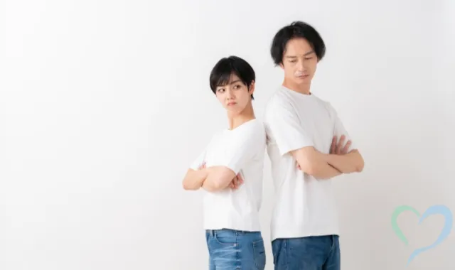 腕組みをする背中合わせの夫婦