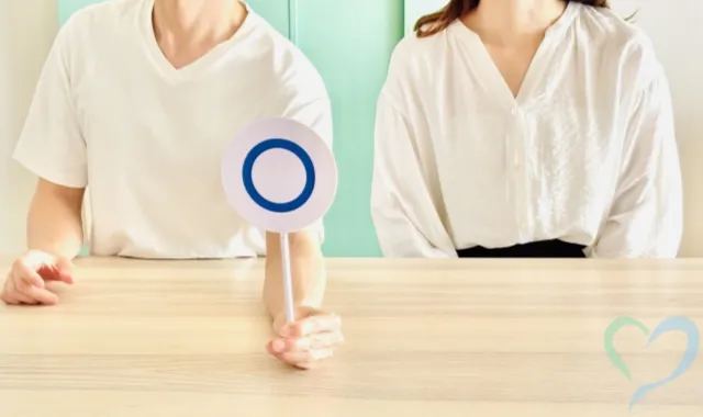 ○の札を出す男性と女性