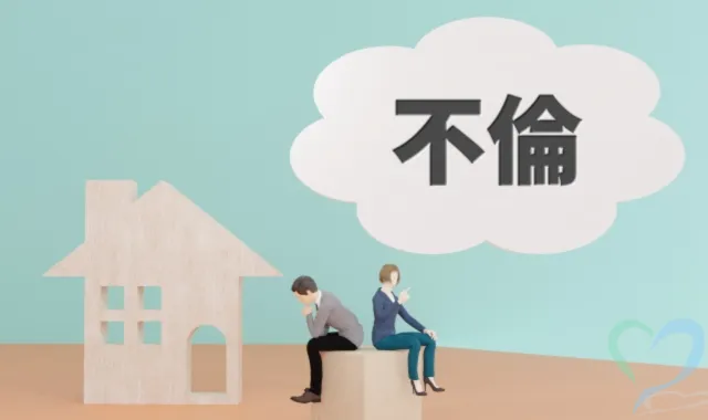 不倫のロゴマークと背を向ける男女を模した人形