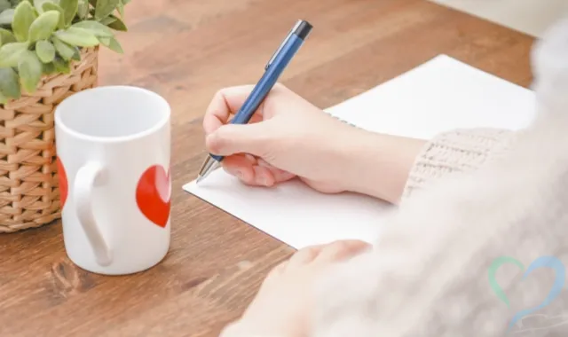 ノートにメモを取る女性