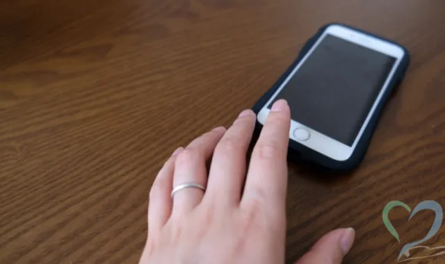 スマートフォンに手を伸ばす女性