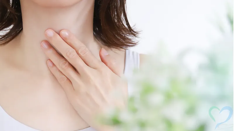 喉を抑える女性