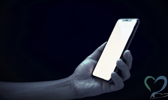 暗闇の中でスマホを手に持ってる様子