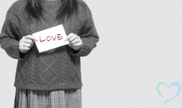 LOVEと書かれた紙を持つ女性