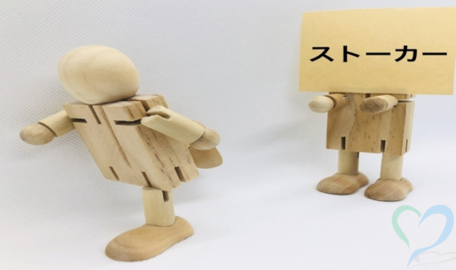 木の人形でストーカーの加害者と被害者を表現