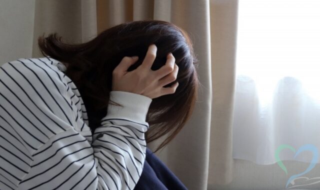 頭を抱えて不安に悩む女性
