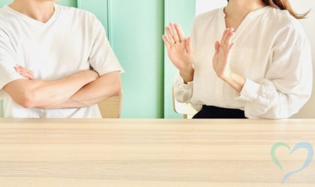 腕を組んで女性に不満をぶつける男性