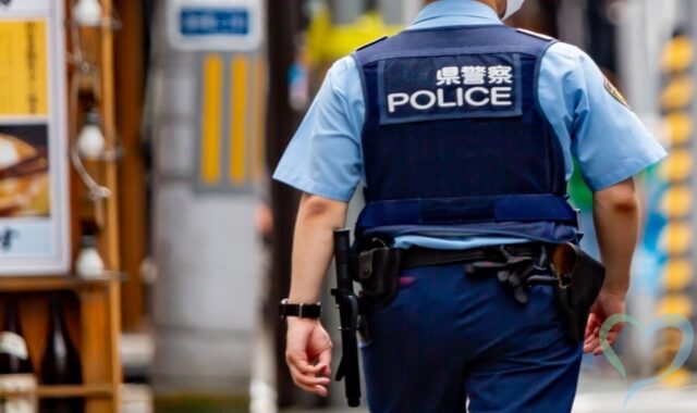 110番通報を表現する警官の後ろ姿