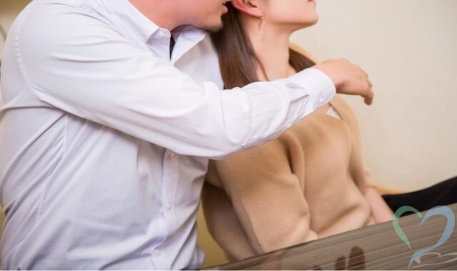 女性の肩に強引に腕を回して接触する男性